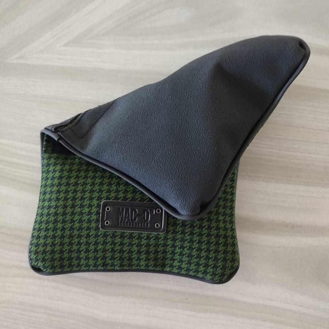 A green and black wallet sitting on top of a table.