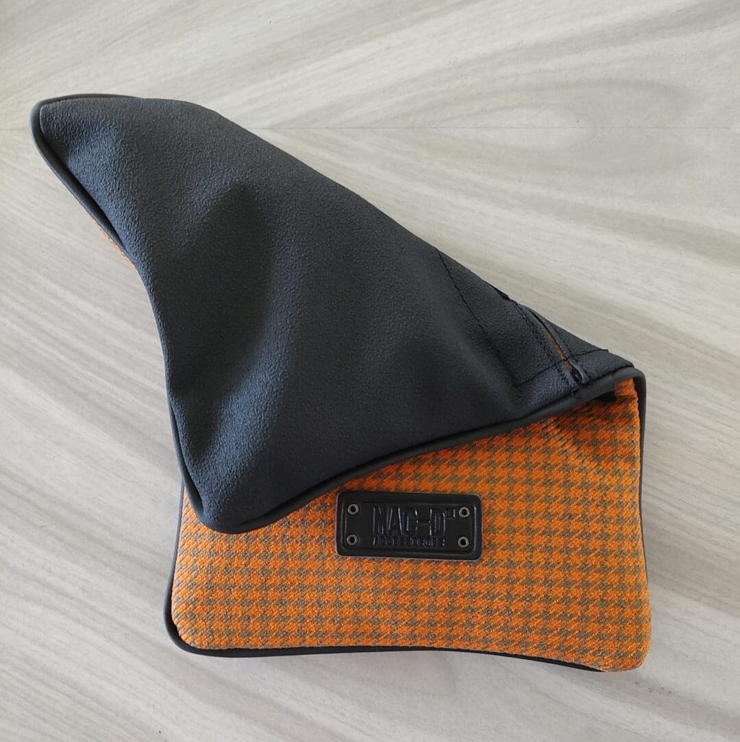 A black and orange bag sitting on top of a wooden table.