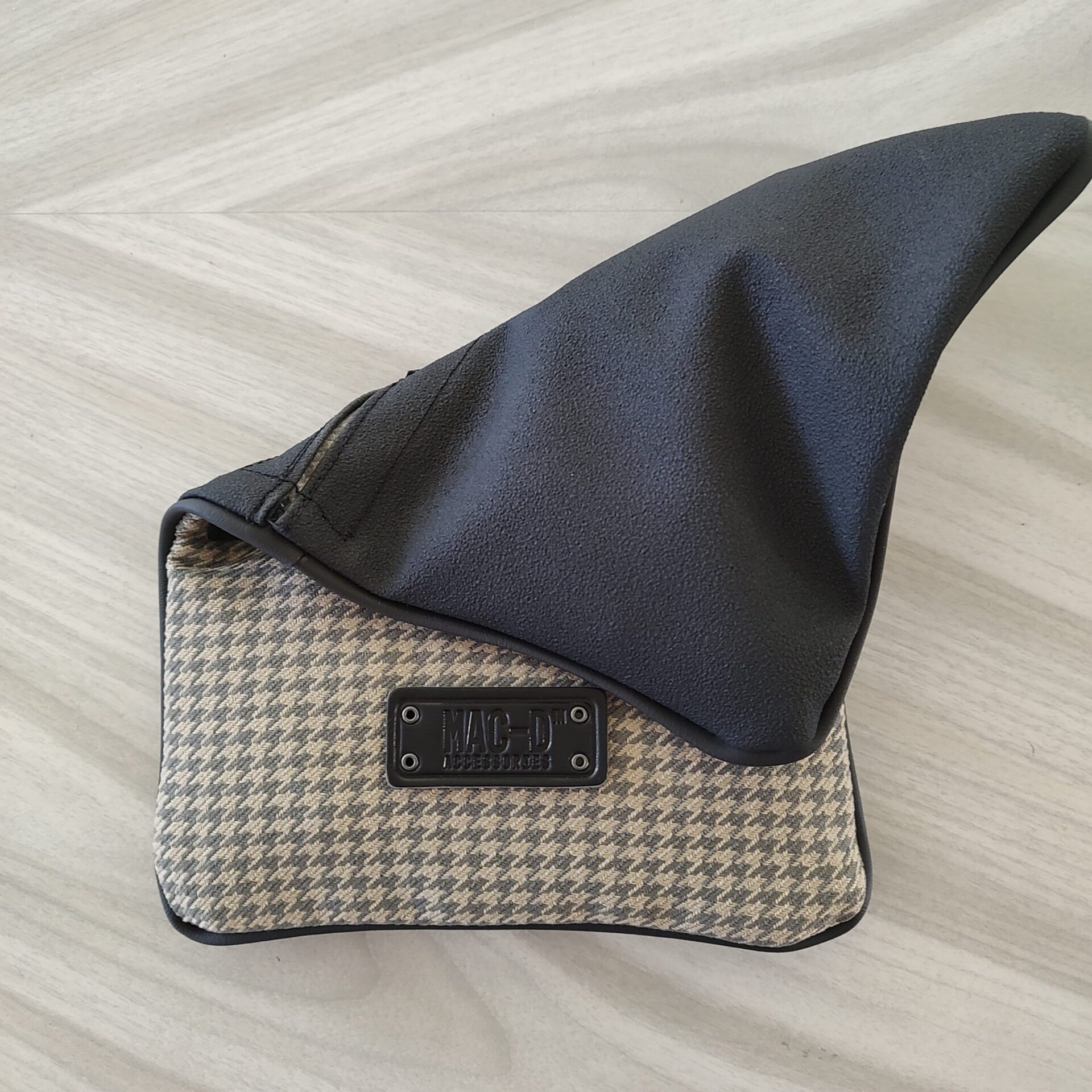 A black and white purse sitting on top of a wooden floor.