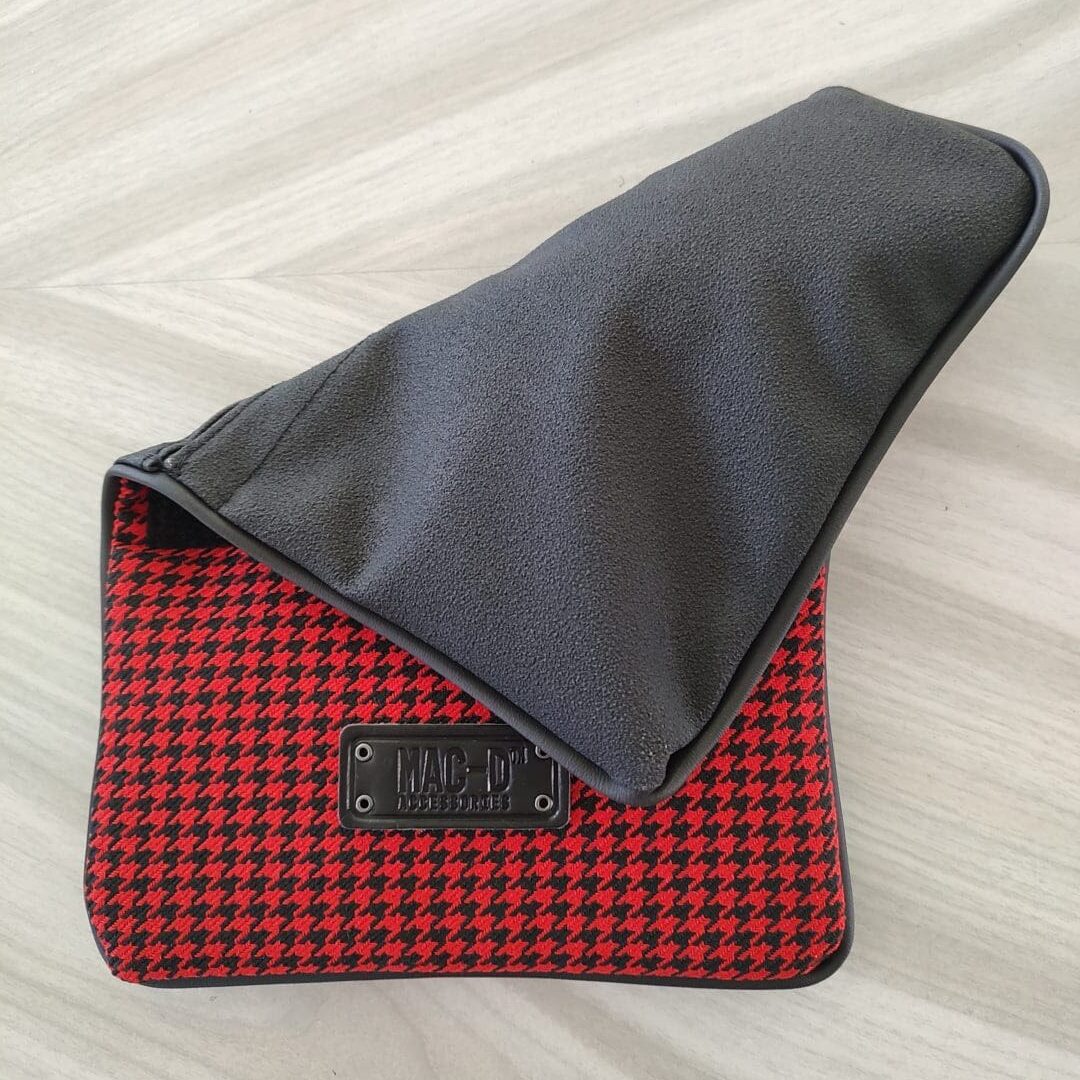 A red and black bag sitting on top of a wooden floor.