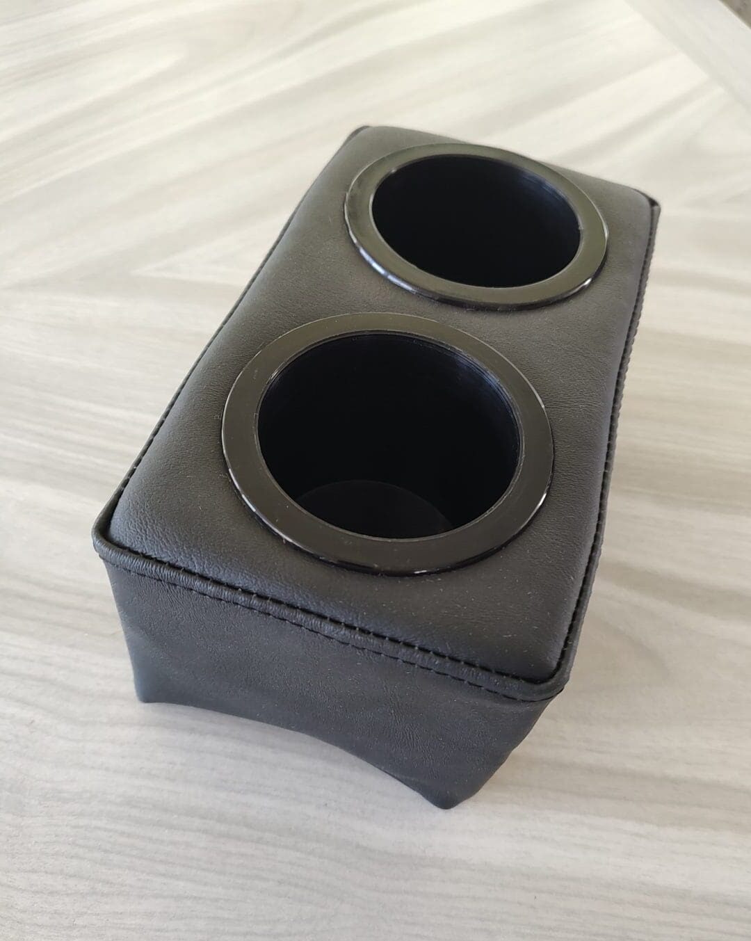 A black leather case with two holes for speakers.