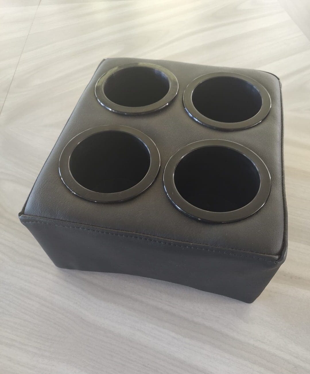 A black box with four holes on top of it.